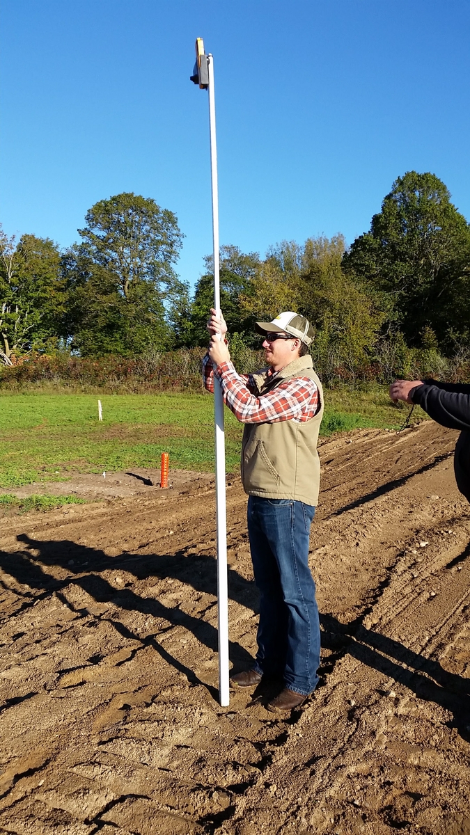 Image of person taking measurements at a project site.