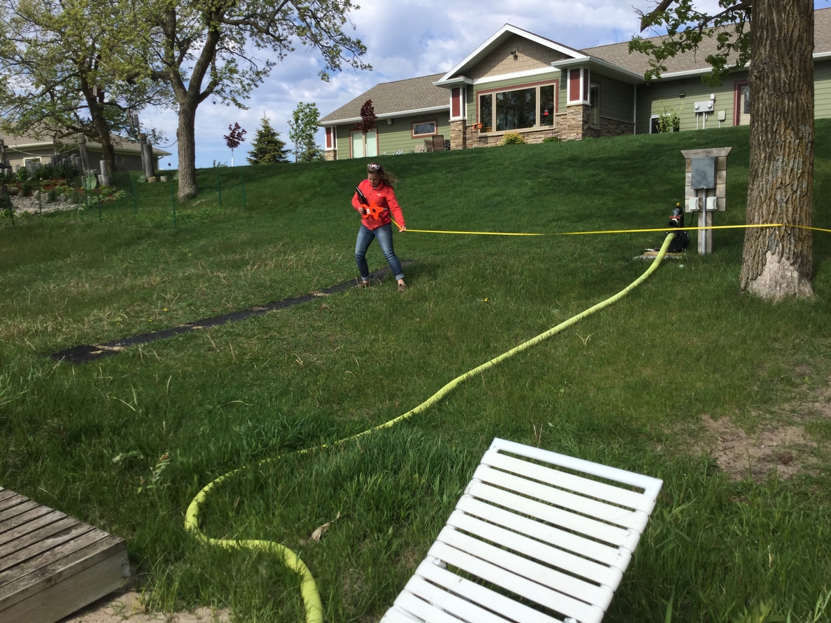 Photo of person taking measurements at a shoreline project site.