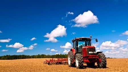 Image of a tractor working in farm field.